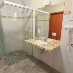 Barrierearmes Bad umbauen: Beispiel mit bodengleicher Dusche, unterfahrbarem Waschtisch und Haltegriffen an Dusche und WC