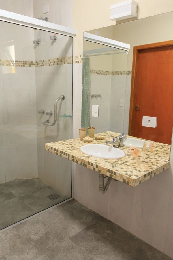 Barrierearmes Bad umbauen: Beispiel mit bodengleicher Dusche, unterfahrbarem Waschtisch und Haltegriffen an Dusche und WC