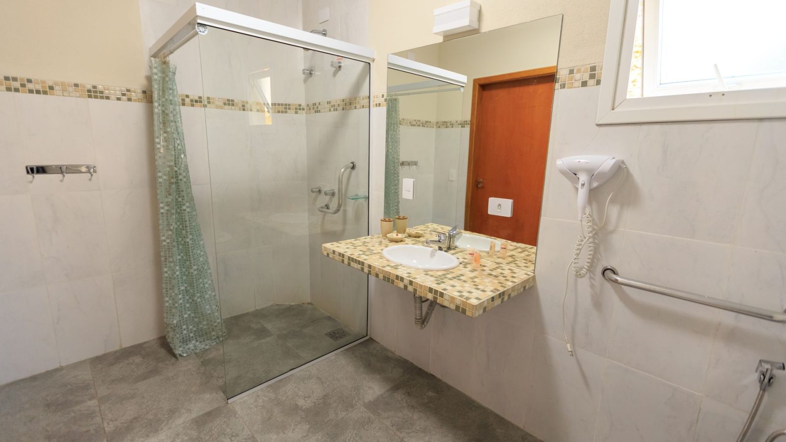 Barrierearmes Bad umbauen: Beispiel mit bodengleicher Dusche, unterfahrbarem Waschtisch und Haltegriffen an Dusche und WC