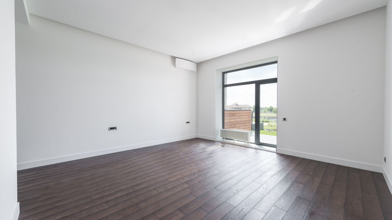 Frisch renovierter Raum mit glatten, weiß gestrichenen Wänden und neuen Sockelleisten