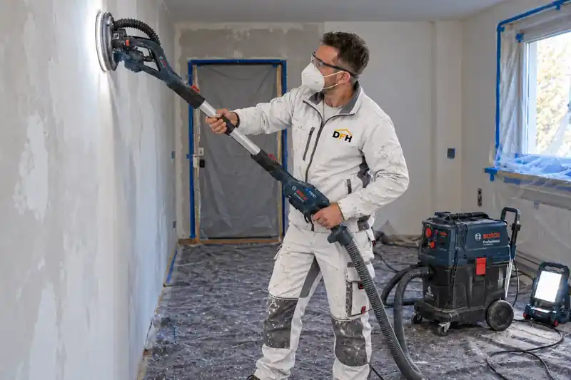 Gespachtelte Wand wird mit Absaugung staubarm geschliffen